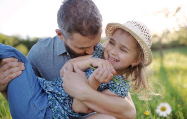 Father playing outdoors with daughter