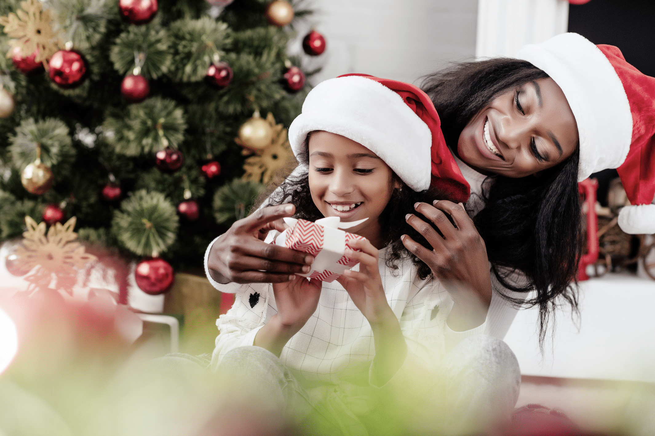 Mom with her daughter opening Christmas present